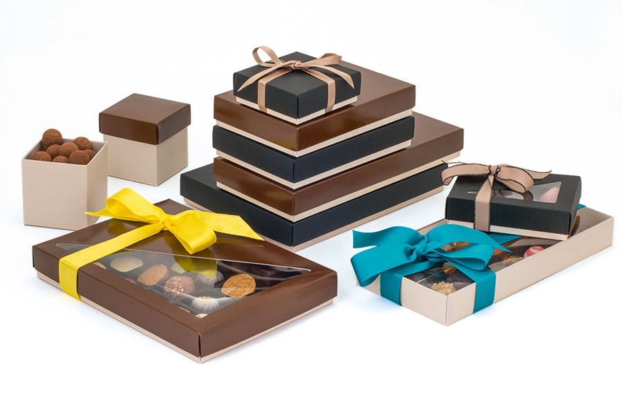 Display-of-salted-caramel-and-cocoa-toned-packaging-of-different-sizes-and-shapes-containing-an-array-of-chocolates-decorated-with-ribbons