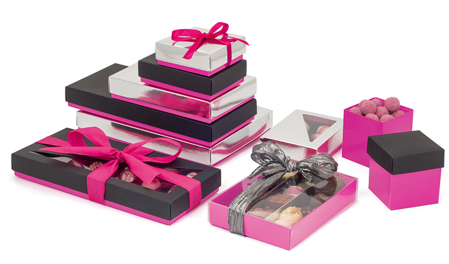 Display-of-hot-pink-packaging-of-different-sizes-and-shapes-containing-an-array-of-chocolates-decorated-with-ribbons